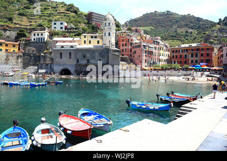 Editorial Bild: Vernazza, Cinque Terre/Italien - 21. Juni 2019: Touristen schwimmen und spazieren am Strand und Hafen der bunten historischen Stadt. Stockfoto