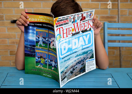 Ein Kind das Lesen der Woche Junior Magazin Britischen wöchentliche Publikation für junge Menschen mit D-Day Memorial vordere Abdeckung in Großbritannien Großbritannien KATHY DEWITT Stockfoto