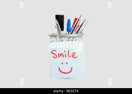 Nahaufnahme der Klebstoff Briefpapier mit Smiley-Gesicht auf Stifthalter auf weißem Hintergrund Stockfoto