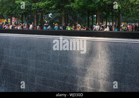 Gedenkstätte vom 11. September, Blick auf die Menschen, die in den riesigen Brunnen des reflektierenden Pools des Nordturms am 11. September in Manhattan, New York City, blicken. Stockfoto