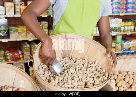 Mittleren Bereich der Verkäuferin mit Korb mit Erdnüssen Stockfoto