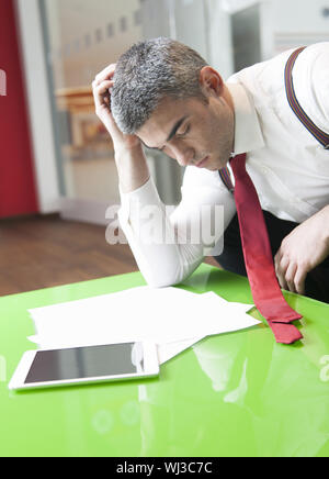 Geschäftsmann, einschlafen, während Dokumente lesen Stockfoto