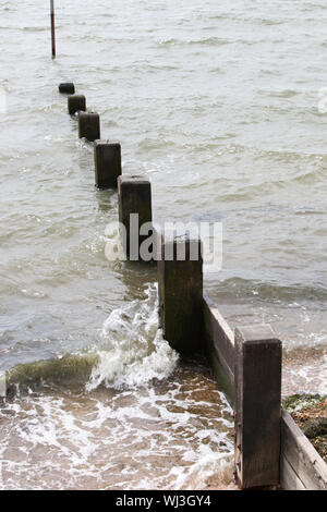 Welle trifft Strand Buhne Stockfoto