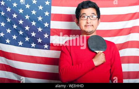 Stolz auf asiatischen Mann, hält Tischtennis Schläger gegen US-Flagge Stockfoto