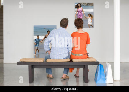 Ansicht der Rückseite des Paares auf der Bank sitzt auf Fotografien, die der künftigen Planung suchen Stockfoto