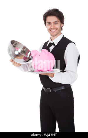 Porträt von einem Butler mit Sparschwein auf einem Tablett. Isoliert auf weiss Stockfoto