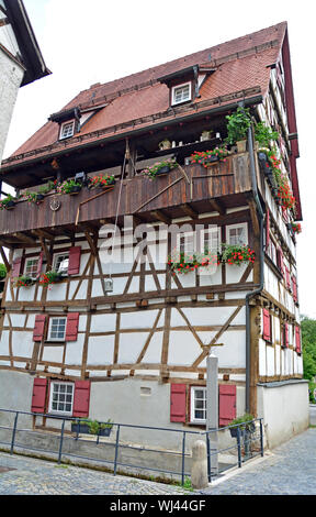 Sechs-stöckiges Fachwerkhaus in der Deutschen Schwäbische Alb Region. Neben einem Kanal gebaut. Eine gefederte Gießkanne liefert das Wasser für die Fenster b Stockfoto