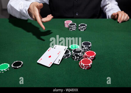 Poker-Spieler ein paar Asse warf, als er seine Hand und Falten während einer Partie Poker in einem Casino Spieltisch erklärt Stockfoto