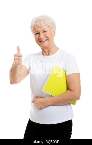 Eine alte Frau hält Arbeitsmappe und zeigt "OK". Isoliert auf weiss. Stockfoto