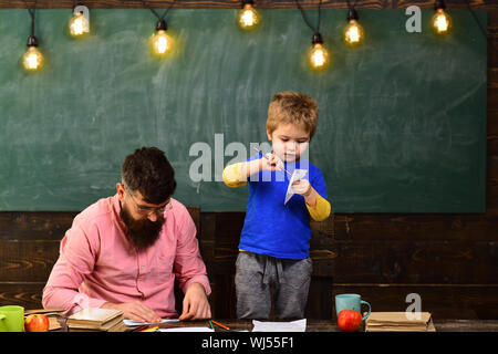 Familie Freizeit Aktivität. Vater und Sohn machen Papier Flugzeuge. Entwickeln Kinder Kreativität Stockfoto