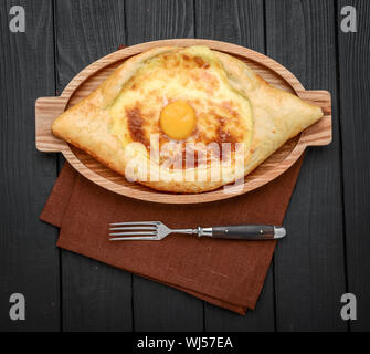 Der luftmischklappe Bestandteile von adjarian Khachapuri mit Gabel im Restaurant. Öffnen Brot Kuchen mit Käse und Eigelb. Lecker georgische Küche. Slow Motion. Stockfoto