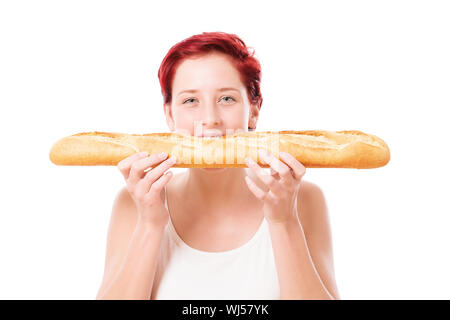 rothaarige Frau beißt in ein Baguette-Brot von Seite auf weißem Hintergrund Stockfoto