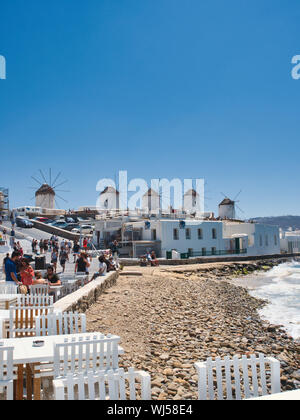 Masse der Reisenden am Meer in der Nähe von alten Windmühlen von Kato Mili an einem sonnigen Tag auf der Insel Mykonos in Griechenland Stockfoto