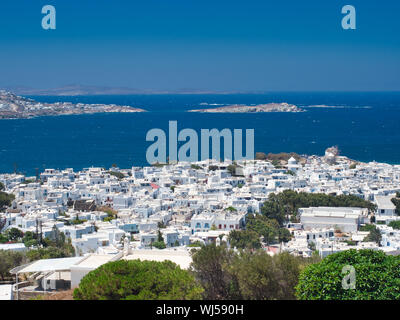 Viele weiße Häuser am Ufer des ruhigen, blauen Meer am wolkenlosen sonnigen Tag auf der Insel Mykonos in Griechenland Stockfoto