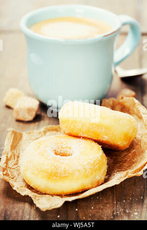 Kaffeepause mit frischem zuckerhaltige Donuts auf weißem Hintergrund Stockfoto