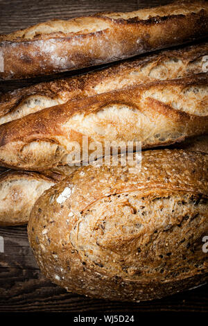 Frisch gebackenes Bauernbrot Brote auf dunklem Holz Stockfoto