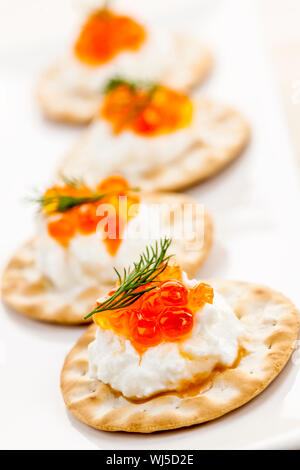 Nahaufnahme von Kaviar und Frischkäse Vorspeise auf Cracker Stockfoto