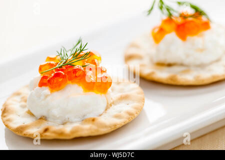 Nahaufnahme von Kaviar und Frischkäse Vorspeise auf Cracker Stockfoto