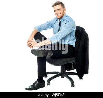Junge Manager auf drehbaren Stuhl sitzend Stockfoto