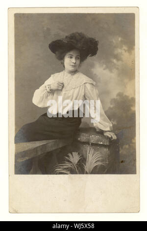 Anfang des 20. Jahrhunderts Studio-Portrait-Postkarte von ziemlich glamourösen jungen Frau trägt einen Hut mit einer Feder in ihm, Spitzenbluse, lose Ärmel, Rock um 1904, Großbritannien Stockfoto