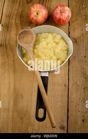 frischer Apfelkompott in einen Topf geben und Holzlöffel Stockfoto
