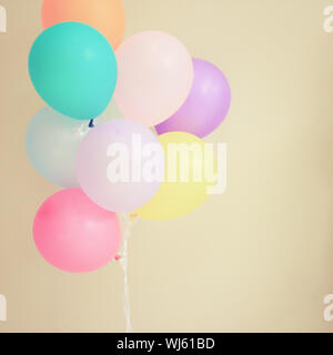 Bunte festliche Ballons auf Wand mit retro Filter Effekt Stockfoto