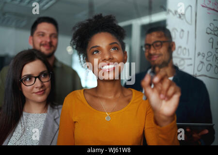 Gruppe Junger erfolgreicher kreativer multiethnische Team lächelnd und Arbeiten in modernen Büro Stockfoto