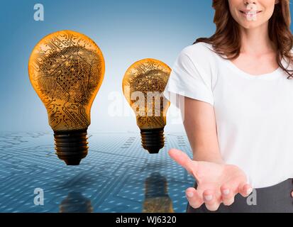 Das zusammengesetzte Bild von attraktiven Geschäftsfrau ihre leere Hand zeigen vor der gelben Glühlampen Stockfoto