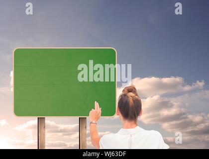 Das zusammengesetzte Bild im Geschäftsfrau auf Schild in den Himmel Stockfoto