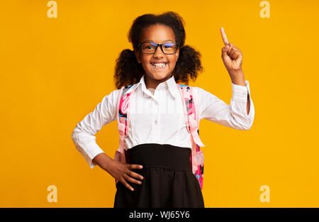 Afrikanische amerikanische Schülerin Zeigefinger auf gelbem Hintergrund Stockfoto