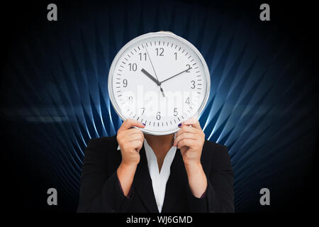 Zusammengesetztes Bild der Geschäftsfrau im Anzug hält eine Uhr Stockfoto