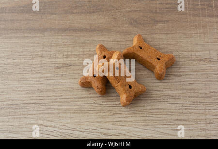 Seitenansicht von drei Erdnussbutter Hundekekse auf eine Tabelle mit natürlichem Licht beleuchtet. Stockfoto