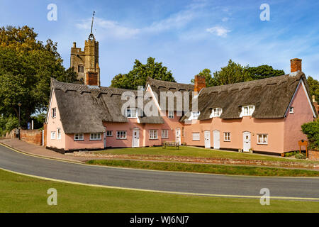 Rosa Cottages mit strohgedeckten Dächern und Blick auf die St. Mary's Church, aus dem Dorf grün, Cavendish, Suffolk, England, Großbritannien, Vereinigtes Königreich Stockfoto