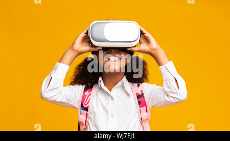 Afro Elementary Student Mädchen mit VR-Headset, Gelber Hintergrund Stockfoto