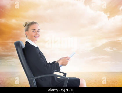 Zusammengesetztes Bild der attraktive blonde Geschäftsfrau sitzt im Drehstuhl hält Ordner Stockfoto