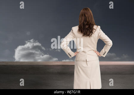 Zusammengesetztes Bild der Geschäftsfrau zurück zu Kamera mit Händen auf den Hüften stehen Stockfoto