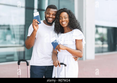 Glücklich lächelnd mit afrikanischen paar Pässe und Tickets am Flughafen außen Stockfoto