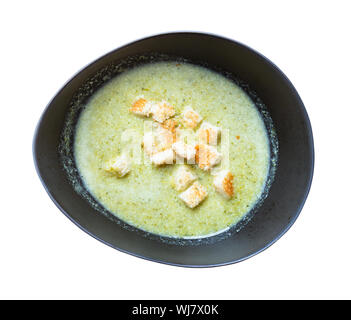 Blick von oben auf die Gemüse Brokkoli Suppe pürieren, mit Sahne und Croutons in Schwarz Keramik Schüssel Ausschnitt auf weißem Hintergrund Stockfoto