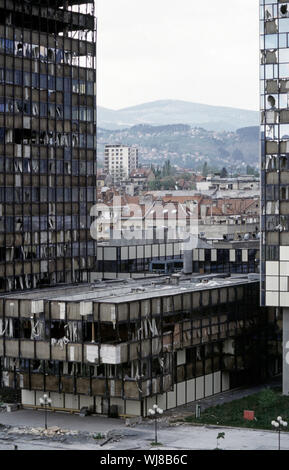 13. Mai 1993 während der Belagerung von Sarajevo: Die Ansicht nord-östlich von der Holiday Inn Hotel. Die beiden stark beschädigten UNIS Türme frame red-roofed Gebäude und die Hügel dahinter. Stockfoto