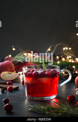 Weihnachten Cranberry und Apple Glühwein garnieren, Rosmarin und Tannenzweigen auf Schwarz. Close Up. Xmas trinken. Stockfoto