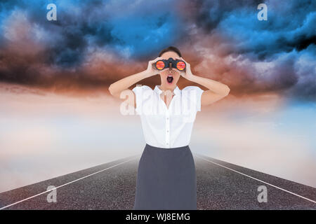 Zusammengesetztes Bild schockiert elegante Geschäftsfrau Blick durch ein Fernglas beim posieren Stockfoto