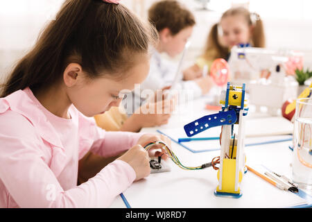 Mädchen arbeiten mit Leitungen und Schaltkreise auf Robotik Projekt Stockfoto
