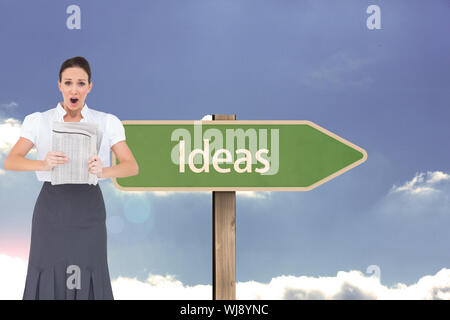 Zusammengesetztes Bild schockiert stilvolle Geschäftsfrau hält Zeitung Stockfoto