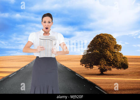 Zusammengesetztes Bild schockiert stilvolle Geschäftsfrau hält Zeitung Stockfoto