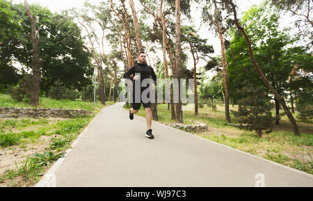 Junge sportliche Mann in bewaldeten Park Stockfoto