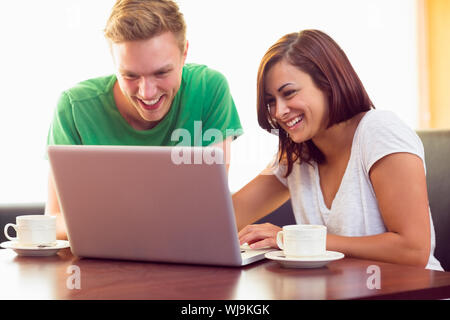 Zwei glückliche Schüler mit Laptop während der Kaffee an der Coffee Shop in Stockfoto