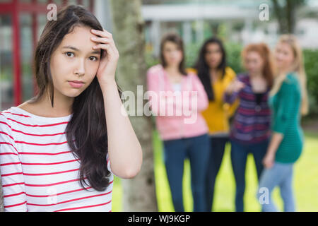 Portrait einer weiblichen Kursteilnehmer, die von anderen Schülern gemobbt, Stockfoto