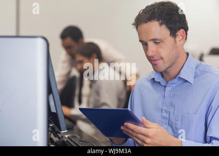 Männliche reife Schüler arbeiten mit einem Grafiktablett sitzen in Computer klasse Stockfoto
