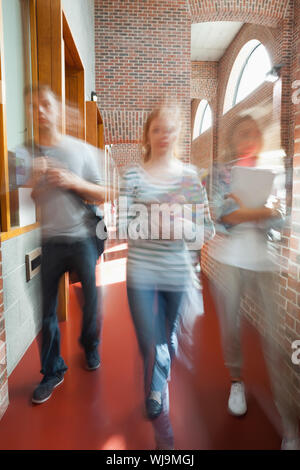 Die Teilnehmer gehen durch Flur in Richtung Kamera in der Schule Stockfoto