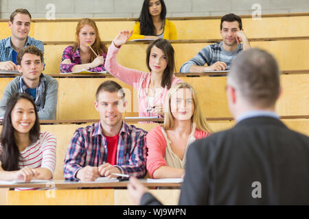 Rückansicht eines eleganten Lehrer mit Schülern an der Hochschule Hörsaal sitzen Stockfoto